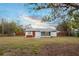 A wide shot of the spacious backyard with a hot tub and screened in porch at 208 Palmetto W Rd, Nokomis, FL 34275