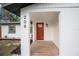 Inviting front porch with a modern wood-look tile floor and a stylish wooden front door with glass inserts at 208 Palmetto W Rd, Nokomis, FL 34275