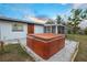 Outdoor hot tub with a wood-look exterior is the focal point of the backyard patio with a screened in porch at 208 Palmetto W Rd, Nokomis, FL 34275