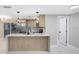 Modern kitchen with stainless steel appliances, waterfall quartz countertop, and stylish pendant lighting at 208 Palmetto W Rd, Nokomis, FL 34275