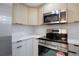 Modern kitchen featuring stainless steel appliances, light wood cabinets, and a white backsplash at 208 Palmetto W Rd, Nokomis, FL 34275