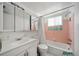 Bathroom with white fixtures, tiled shower and vanity with medicine cabinet at 2113 Canal Dr # B2, Bradenton, FL 34207