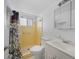 Bathroom featuring a yellow tiled shower, white toilet and sink, offering a clean and functional space at 2113 Canal Dr # B2, Bradenton, FL 34207