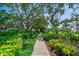Scenic walkway meandering through well-maintained grounds with mature trees and tropical foliage at 2113 Canal Dr # B2, Bradenton, FL 34207