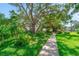 Well-manicured grounds feature a tranquil walkway shaded by mature trees and lush tropical landscaping at 2113 Canal Dr # B2, Bradenton, FL 34207