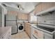 The kitchen has stainless steel appliances, a washer/dryer combo unit, and light wood cabinets at 2113 Canal Dr # B2, Bradenton, FL 34207