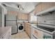 Functional kitchen featuring tile floors, white appliances, and compact washer/dryer unit at 2113 Canal Dr # B2, Bradenton, FL 34207
