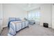 This well-lit bedroom is carpeted and contains two beds, a large window, and a dark grey stool at 2242 Donato Dr, Belleair Beach, FL 33786