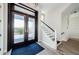 Bright foyer featuring glass-paneled double doors, a staircase with white railings, and a modern wood-look floor at 2242 Donato Dr, Belleair Beach, FL 33786