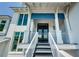 Inviting entryway with double doors and a charming staircase leading to the main level, all set under a bright blue awning at 2242 Donato Dr, Belleair Beach, FL 33786