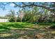 Expansive backyard with lush green grass and a charming swing set hanging from a mature tree branch at 2251 Glenmoor N Rd, Clearwater, FL 33764