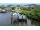 Beautiful waterfront property featuring a private dock, boat lift, and lush landscaping for outdoor enjoyment at 4054 Rocky Shores Dr, Tampa, FL 33634
