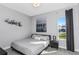 Bedroom features a grey and white patterned bedspread, wall art, and a window at 4054 Rocky Shores Dr, Tampa, FL 33634