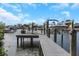 Private boat dock on the canal with a boat lift, chairs, and a table for waterside enjoyment at 4054 Rocky Shores Dr, Tampa, FL 33634