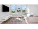 Living room with views, white sofa, light wood floors, modern rug and white shelving at 4054 Rocky Shores Dr, Tampa, FL 33634