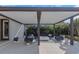 Inviting outdoor patio area with a covered seating area, modern fireplace, and lush tropical landscaping at 4054 Rocky Shores Dr, Tampa, FL 33634