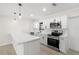 Modern kitchen featuring white cabinetry, stainless steel appliances, quartz countertops and pendant lighting at 4206 Empire Pl, Tampa, FL 33610