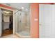 Tiled shower with glass enclosure and built-in seat near the walk-in closet and peach-colored walls at 501 Mandalay Ave # 601, Clearwater Beach, FL 33767