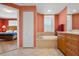 Bathroom with a soaking tub, vanity with cabinet storage, and a window offering natural light at 501 Mandalay Ave # 601, Clearwater Beach, FL 33767