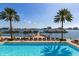 Resort-style pool with lounge chairs and palm trees overlooking the harbor at 501 Mandalay Ave # 601, Clearwater Beach, FL 33767