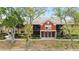 Well-maintained condo building featuring a red accent wall and lush, mature trees in a desirable location at 5618 Baywater Dr # 5618, Tampa, FL 33615