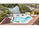 Aerial view of the community pool, lounge chairs, tiki hut, and pond at 5618 Baywater Dr # 5618, Tampa, FL 33615