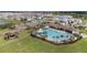 Aerial view of community pool, playground, lush lawns, and water views at 5640 Wandering Willow Dr, Wesley Chapel, FL 33545