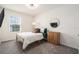 Bright bedroom with a window offers a comfortable space with a full bed, dresser, and clean minimalist finishes at 5640 Wandering Willow Dr, Wesley Chapel, FL 33545