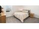 Inviting bedroom with a queen-sized bed, plush carpeting, and natural light from the window at 5640 Wandering Willow Dr, Wesley Chapel, FL 33545