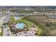 Aerial view of a community pool, playground, and lush green space near homes and a pond at 5640 Wandering Willow Dr, Wesley Chapel, FL 33545