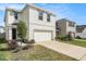 Two-story home features a two-car garage, well-manicured lawn, and tasteful landscaping at 5640 Wandering Willow Dr, Wesley Chapel, FL 33545