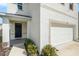 Attractive home exterior featuring a two-car garage, covered entry, and neatly landscaped front yard at 5640 Wandering Willow Dr, Wesley Chapel, FL 33545