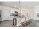 Modern kitchen featuring a large island with barstool seating, stainless appliances, and pendant lights at 5640 Wandering Willow Dr, Wesley Chapel, FL 33545