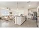 Open concept kitchen and living room featuring a large island and stainless appliances at 5640 Wandering Willow Dr, Wesley Chapel, FL 33545