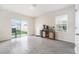Open-concept living space with tile flooring, sliding glass doors to the patio, and a beverage center at 5640 Wandering Willow Dr, Wesley Chapel, FL 33545