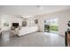 Bright living room featuring tile floors, large sectional sofa, and access to outdoor patio at 5640 Wandering Willow Dr, Wesley Chapel, FL 33545