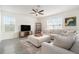 Bright living room showcasing a sectional sofa, modern ceiling fan, and a large flat-screen television at 5640 Wandering Willow Dr, Wesley Chapel, FL 33545