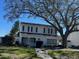 Charming two-story home with green shutters and a mature tree in the front yard at 631 Hudson Ave, Tampa, FL 33606