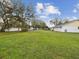 Expansive lawn in backyard featuring mature trees and white fencing at 7806 Providence Rd, Riverview, FL 33578