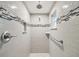 Clean white tiled shower includes a shower head and safety bar at 7806 Providence Rd, Riverview, FL 33578