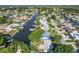 Expansive aerial view of a waterfront community with lush greenery, canals, and diverse housing options near the bay at 8704 Thornwood Ln, Tampa, FL 33615