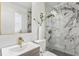 Modern bathroom with marble-style shower, floating vanity, and contemporary fixtures at 8704 Thornwood Ln, Tampa, FL 33615