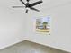 Minimalist bedroom with terrazzo floors, ceiling fan and view of the neighborhood at 8704 Thornwood Ln, Tampa, FL 33615