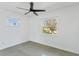 Well-lit bedroom with two windows and modern ceiling fan, offering a minimalist aesthetic at 8704 Thornwood Ln, Tampa, FL 33615