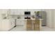 Modern kitchen featuring stainless steel appliances, an island with seating, and white cabinets at 9324 Bonita Mar Dr, Parrish, FL 34219