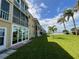 Exterior view of a waterfront condo with a grassy lawn, palm trees, and beautiful views at 1 Boca Ciega Point Blvd # 213, St Petersburg, FL 33708