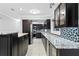 Modern kitchen with granite countertops, dark cabinets, stainless steel appliances and tiled floors at 101 30Th N Ave, St Petersburg, FL 33704
