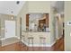 Open kitchen view with breakfast bar, wooden stools, and hardwood floors transitioning into the entryway at 10340 Lightner Bridge Dr, Tampa, FL 33626