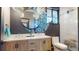 Modern bathroom featuring a double sink vanity, moon-shaped mirror, and glass shower at 10787 Oak Ne St, St Petersburg, FL 33716