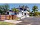Well-maintained white building with black trim, lush landscaping, a wooden fence, and ample parking space at 10787 Oak Ne St, St Petersburg, FL 33716